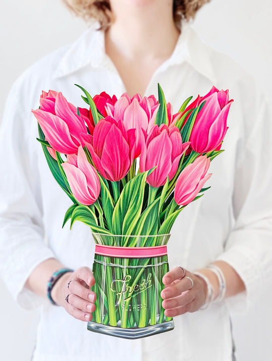 woman holding pink tulip bouquet