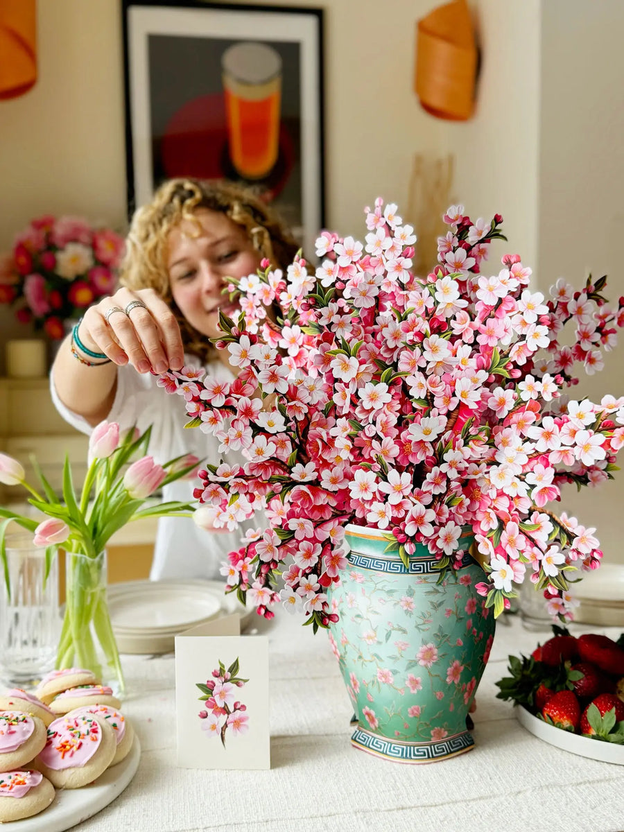 a woman arranging flowers in a vase