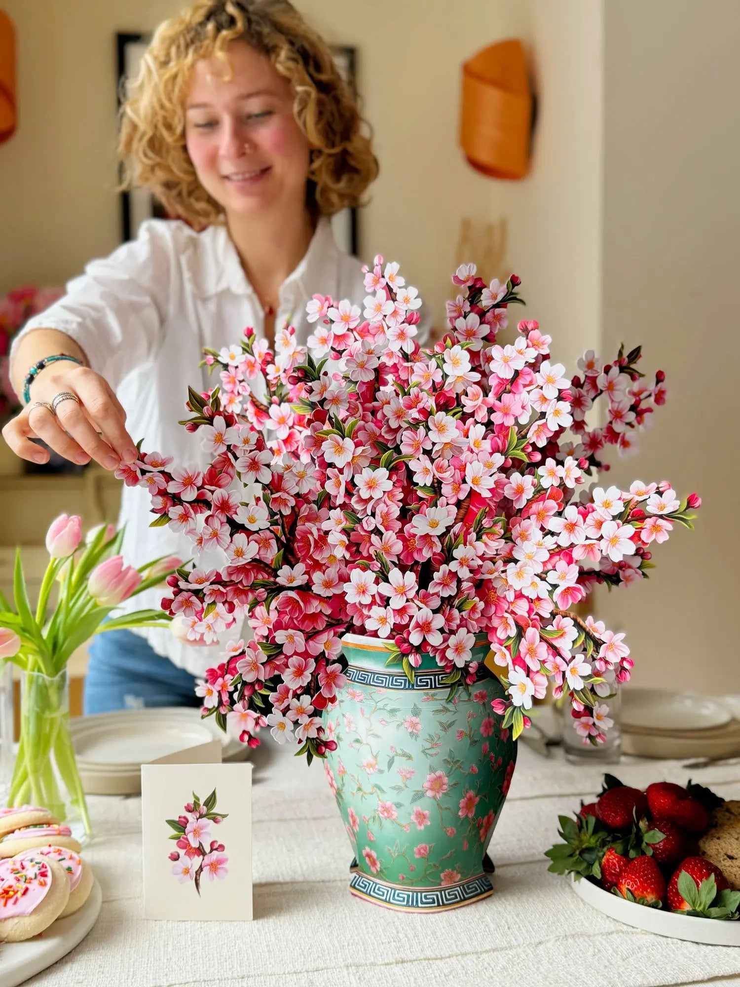 a woman putting flowers in a vase