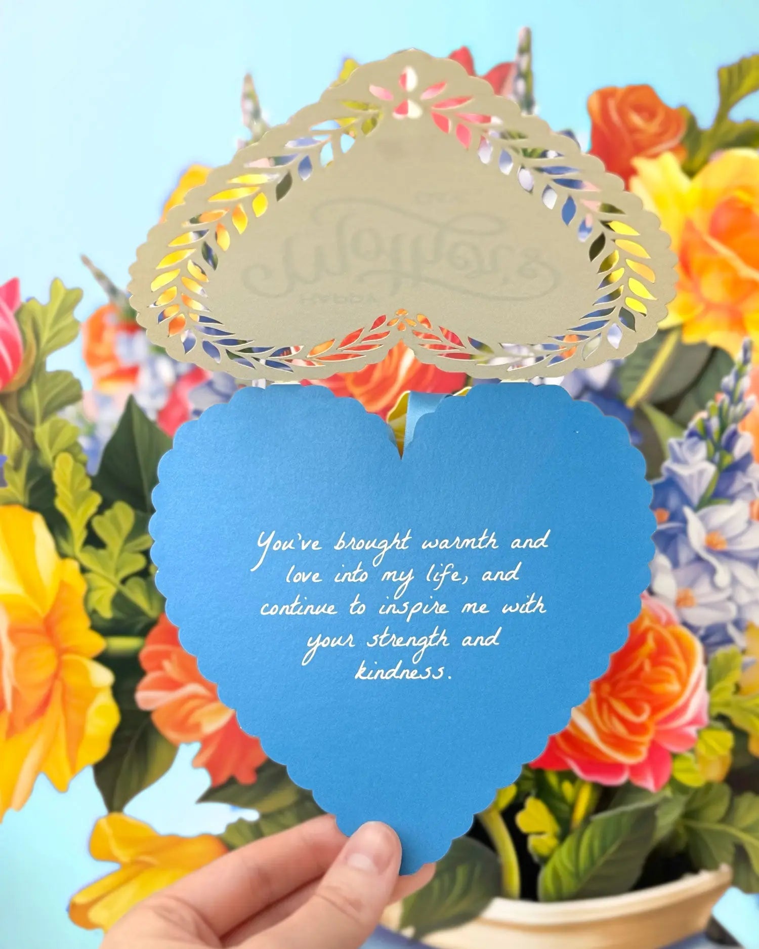 a hand holding a blue heart shaped card