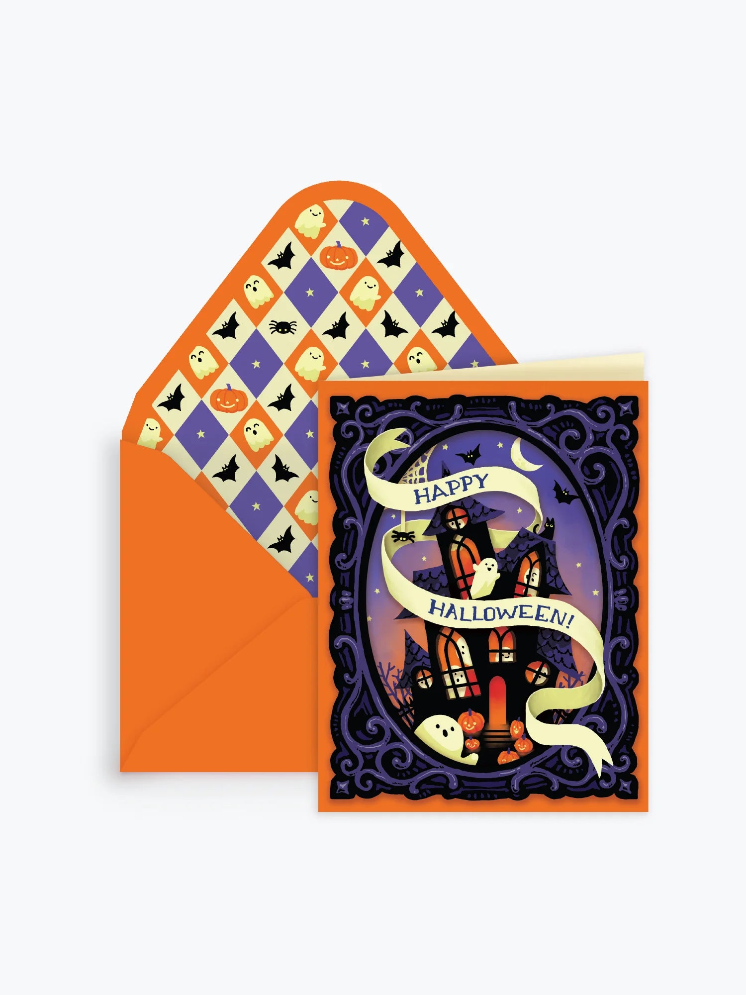 A Halloween greeting card and matching envelope on a light gray background. The card features a purple night sky with a haunted house, bats, a cat, and a cream banner reading 'Happy Halloween!'.