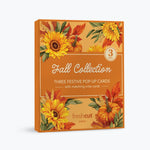 A boxed card set of 3 titled 'Fall Collection' with autumn-themed illustrations of sunflowers, pumpkins, leaves, and wheat on an orange background. The front text reads 'Three Festive Pop-Up Cards with matching note cards' and shows the FreshCut Paper brand logo