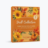 A boxed card set of 3 titled 'Fall Collection' with autumn-themed illustrations of sunflowers, pumpkins, leaves, and wheat on an orange background. The front text reads 'Three Festive Pop-Up Cards with matching note cards' and shows the FreshCut Paper brand logo