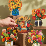 A hand holds a small woven basket filled with autumn flowers and decorative stems, surrounded by several other floral arrangements in colorful vases and pots on wooden blocks against a warm sage green wall.