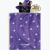 A purple Halloween-themed envelope with white star patterns, featuring a cartoon black cat in a purple witch hat peeking out above the top edge, with a 'Happy Halloween' speech bubble. The brand name 'freshcut paper' is printed near the bottom.