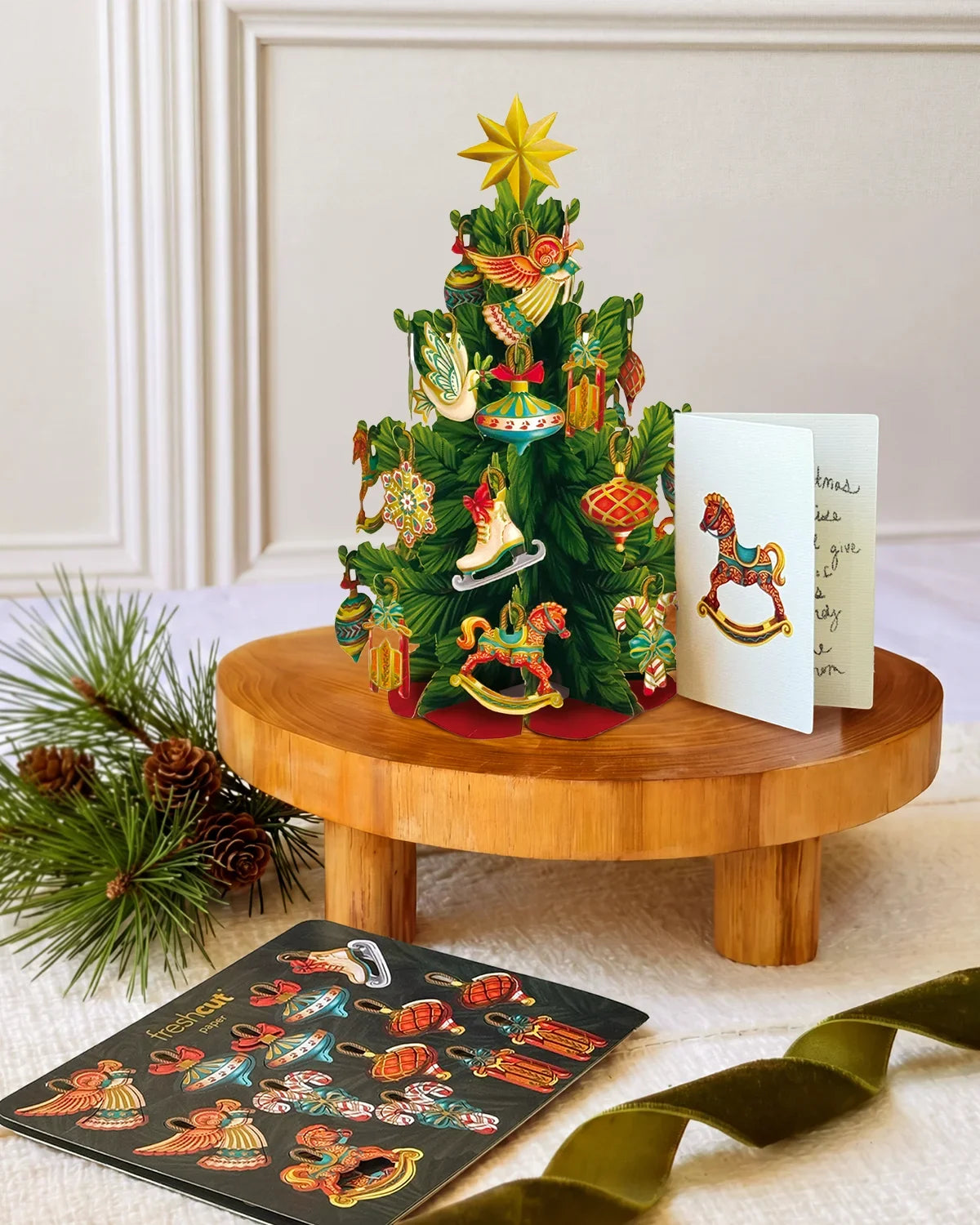 Mini Christmas Tree pop-up decoration displayed on a table with its matching holiday notecard and ornament sheet.